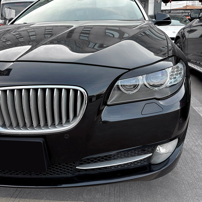 BMW F10/F11 Prefacelift glossy black headlight eyebrow accents installed on front bumper detail view