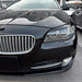 BMW F10/F11 Prefacelift glossy black headlight eyebrow accents installed on front bumper detail view