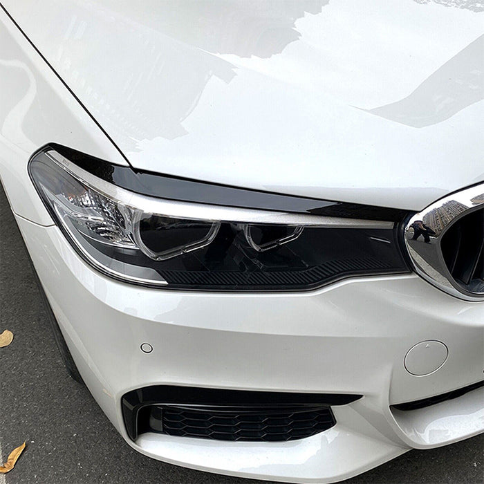 Glossy black eye shades eyebrows for BMW G30 2018-2020 headlight trim installed on white sedan