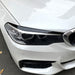 Glossy black eye shades eyebrows for BMW G30 2018-2020 headlight trim installed on white sedan