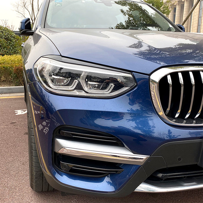 Black eyebrow shades for BMW X3 G01 2018-2021, headlight accent surrounds installed on blue vehicle
