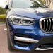 Black eyebrow shades for BMW X3 G01 2018-2021, headlight accent surrounds installed on blue vehicle