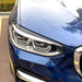Black eyebrow trim eyelid installed on BMW X3 G01 headlight, gloss finish, front view